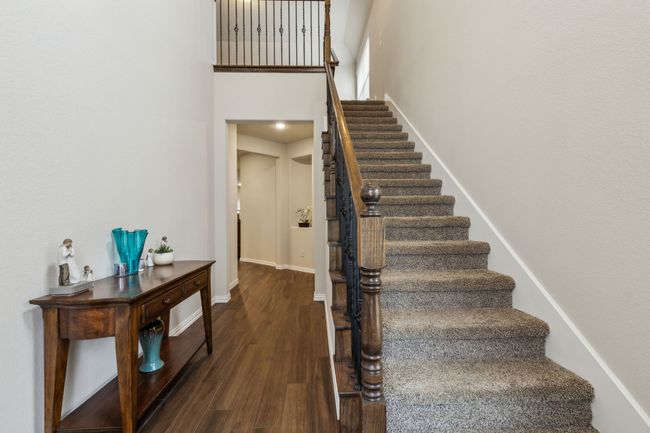 Stairs with wood finished floors, baseboards, and a high ceiling | Image 6