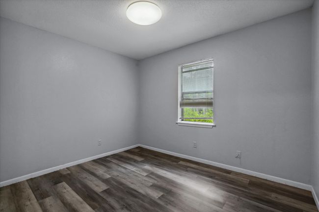 Spare room with dark wood-type flooring and baseboards | Image 12