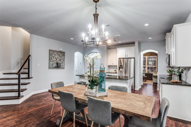 Dining area with arched walkways, recessed lighting, dark wood-style flooring, and a chandelier | Image 15