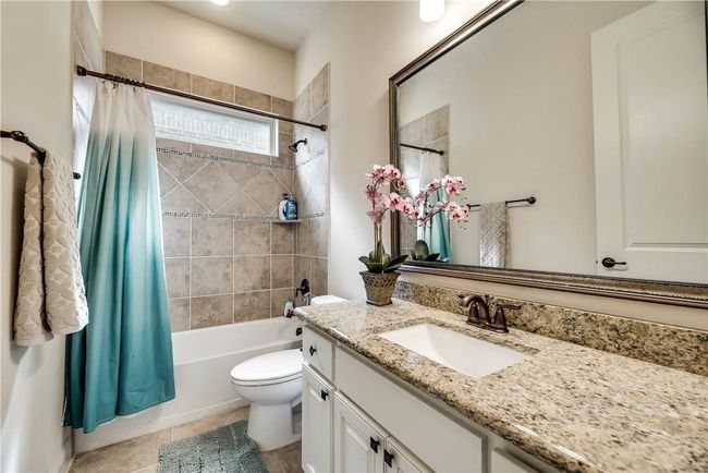 Full bathroom with vanity, toilet, shower / tub combo with curtain, and tile patterned floors | Image 26