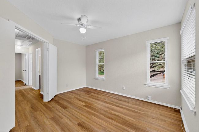 Unfurnished room with light wood-type flooring, a ceiling fan, baseboards, and attic access | Image 20