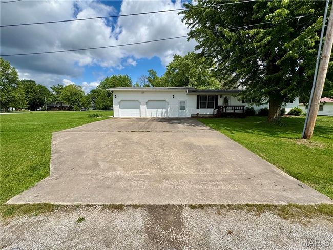 Ranch-style home featuring a front yard, an attached garage, and concrete driveway | Image 11