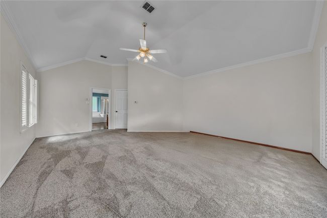 Spare room featuring a ceiling fan, ornamental molding, vaulted ceiling, and carpet floors | Image 22
