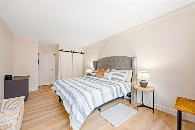Bedroom featuring wood finished floors, baseboards, and a barn door | Image 12