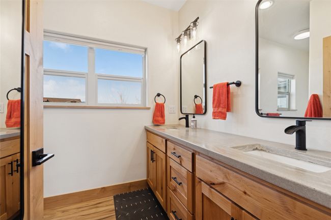 Bathroom with a sink, baseboards, double vanity, and wood finished floors | Image 30