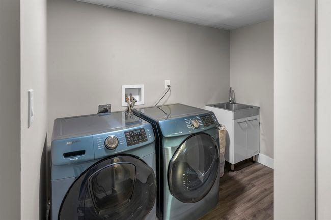 Laundry area with laundry area, independent washer and dryer, a sink, baseboards, and dark wood-style floors | Image 24