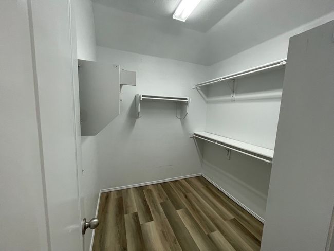 Walk in closet featuring dark wood-type flooring | Image 14