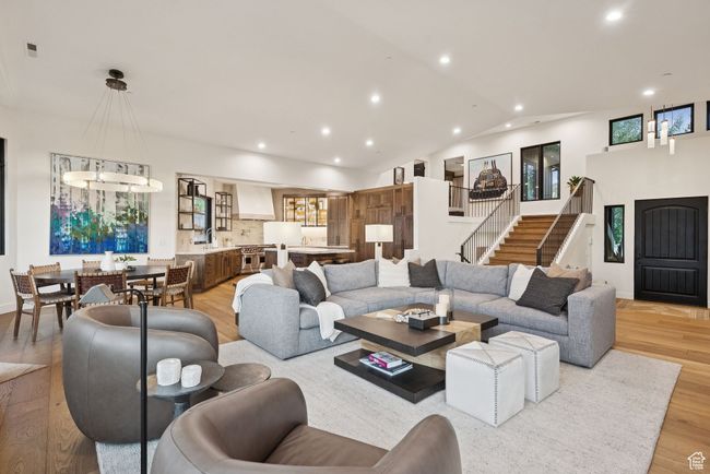 Living area with recessed lighting, light wood-type flooring, vaulted ceiling, and stairs | Image 14