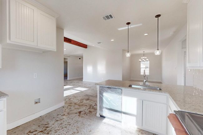 Kitchen featuring light stone countertops, white cabinets, visible vents, a sink, and electric range oven | Image 13