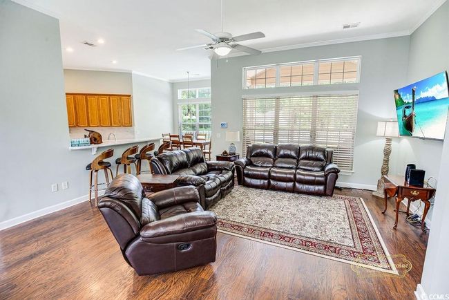 Living room featuring a ceiling fan, wood finished floors, ornamental molding, and recessed lighting | Image 8