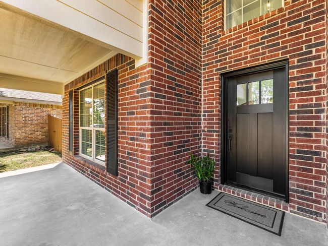 View of exterior entry with brick siding and a porch | Image 5