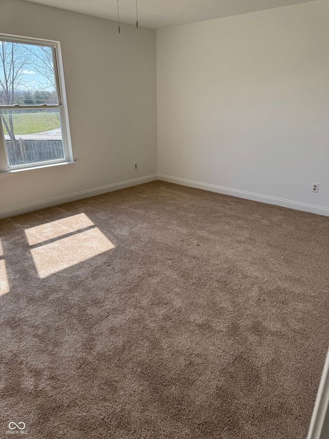 empty room with baseboards, a textured ceiling, and carpet | Image 15