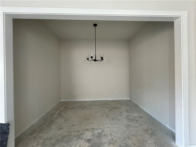 Unfurnished dining area with concrete flooring and baseboards | Image 8