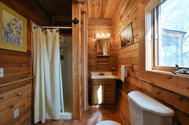 The bathroom has a shower and small vanity. | Image 75
