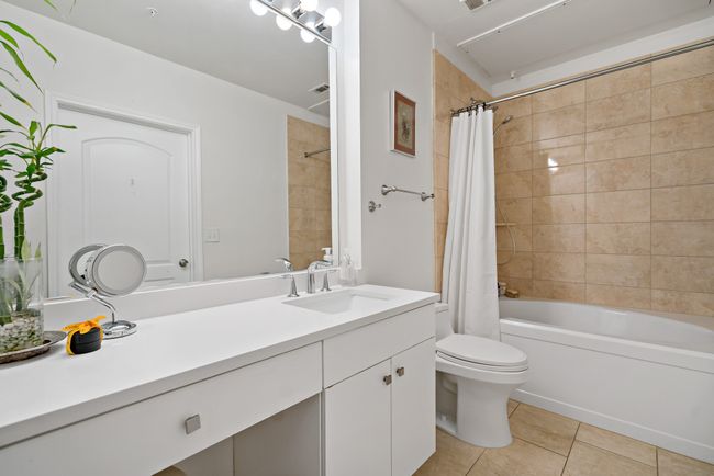 Bathroom with visible vents, tile patterned flooring, vanity, toilet, and shower / bathtub combination with curtain | Image 20