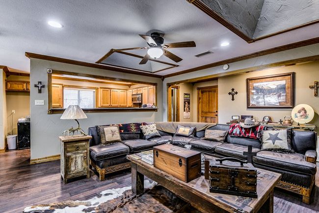 Living room with ornamental molding, a ceiling fan, dark wood-type flooring, recessed lighting, and a textured ceiling | Image 8