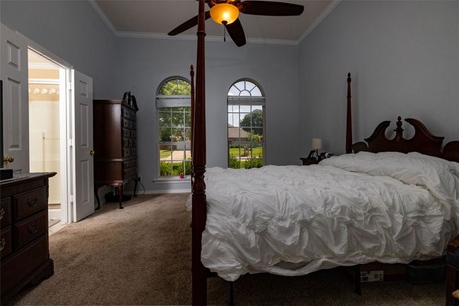 Bedroom featuring carpet, a ceiling fan, ornamental molding, and connected bathroom | Image 24