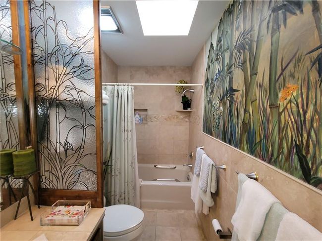 Bathroom featuring toilet, shower / tub combo with curtain, vanity, and tile patterned flooring | Image 48