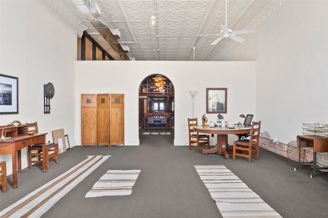 Dining space with arched walkways, ceiling fan, carpet floors, a towering ceiling, and an ornate ceiling | Image 4