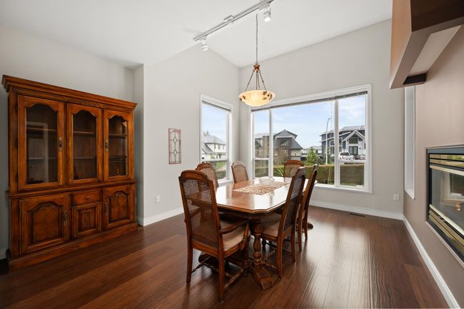 Dining room with lofted ceiling, dark wood-style floors, baseboards, and track lighting | Image 6