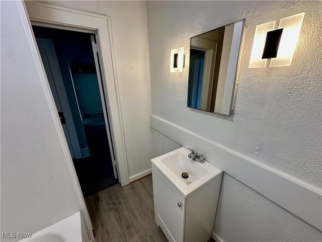 Bathroom featuring a textured wall, vanity, and wood finished floors | Image 9