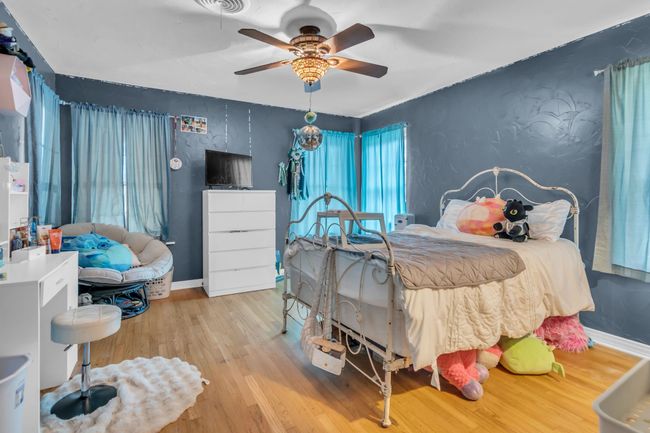 Bedroom with wood finished floors and ceiling fan | Image 20