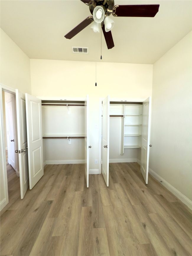Unfurnished bedroom featuring light wood finished floors, ceiling fan, and baseboards | Image 15