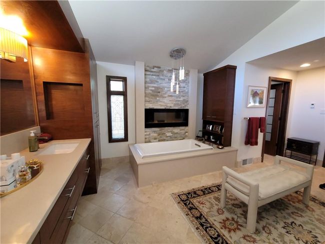 Bathroom with visible vents, vanity, a garden tub, a glass covered fireplace, and vaulted ceiling | Image 29