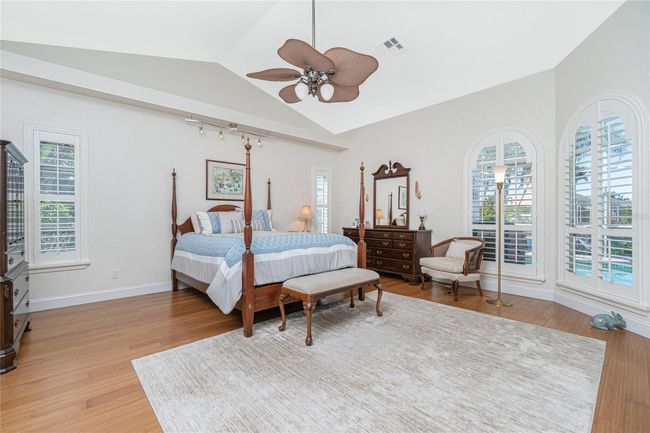 Spacious primary bedroom ensuite has bamboo flooring and cathedral ceiling | Image 36