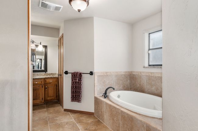 Full bathroom featuring a garden tub, visible vents, vanity, and baseboards | Image 23