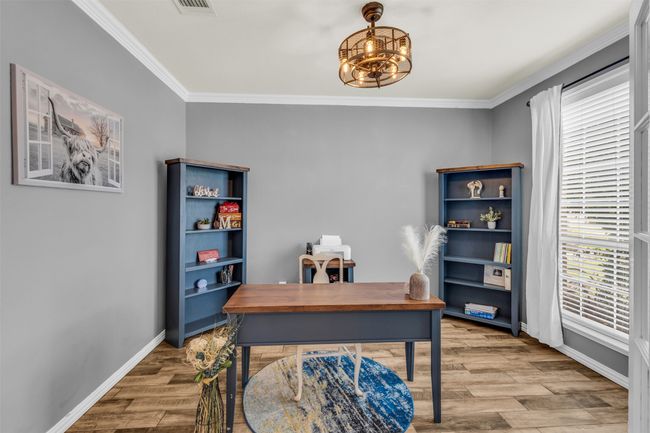 Office space with ornamental molding, light wood-type flooring, and a notable chandelier | Image 5