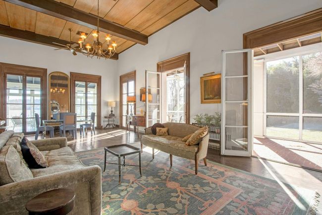 Living room with hardwood / wood-style flooring, lofted ceiling with beams, wood ceiling, and an inviting chandelier | Image 9