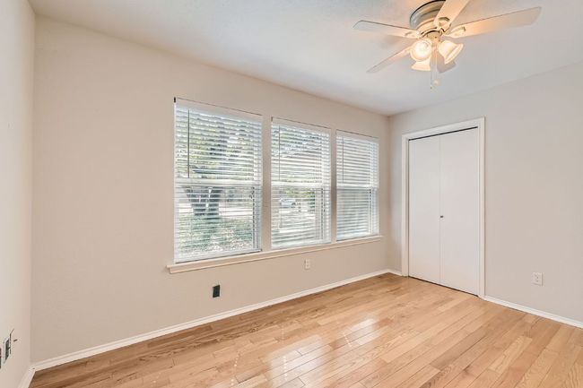 Unfurnished bedroom with baseboards, light wood finished floors, and multiple windows | Image 13