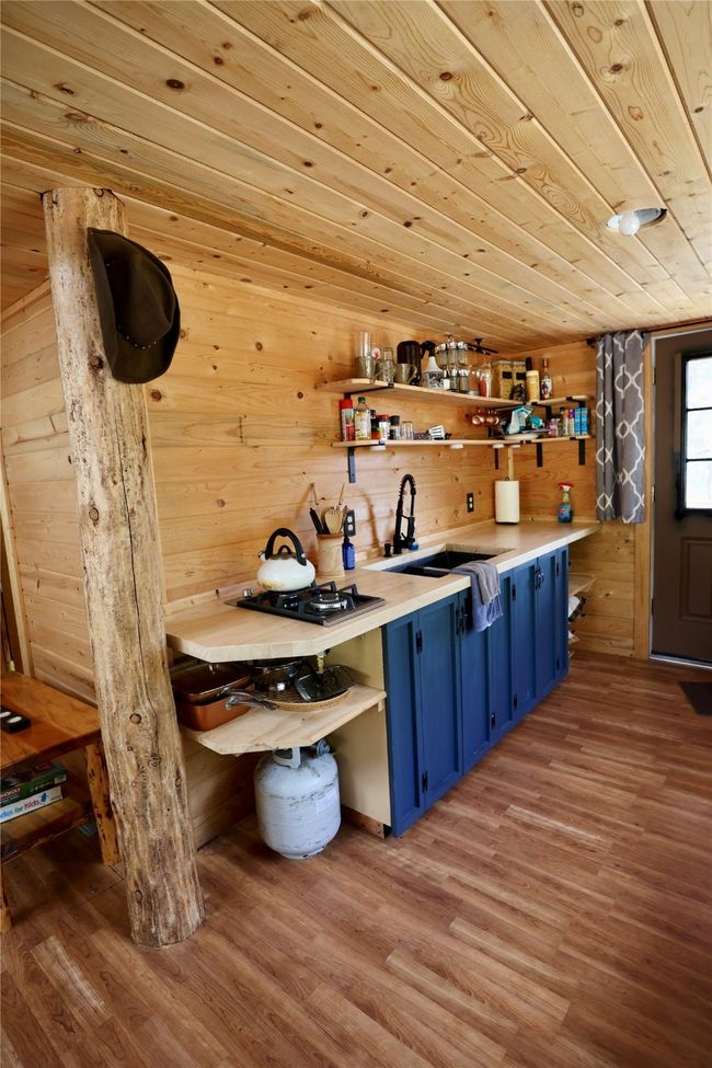 Bar featuring a sink, light wood-style flooring, wood walls, and wood ceiling | Image 42