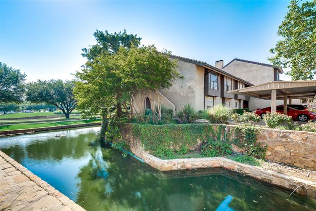 Rear view of property with a water view, stucco siding, and a chimney | Image 27