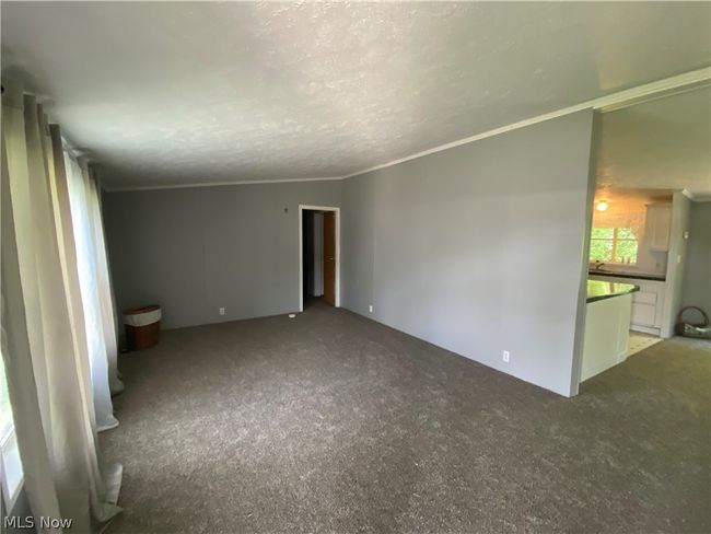 Empty room featuring a textured ceiling, carpet floors, and crown molding | Image 2