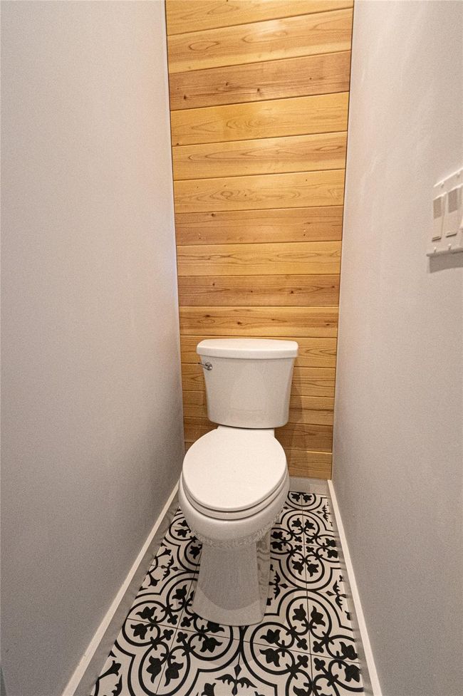 Bathroom with wood walls and tile patterned floors | Image 15