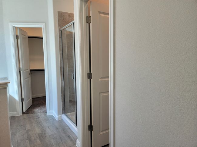 Bathroom with a stall shower, wood finished floors, and a walk in closet | Image 14