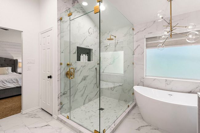 Expansive walk-in shower with floor-to-ceiling tile and upscale fixtures elevates the primary bathroom experience | Image 21