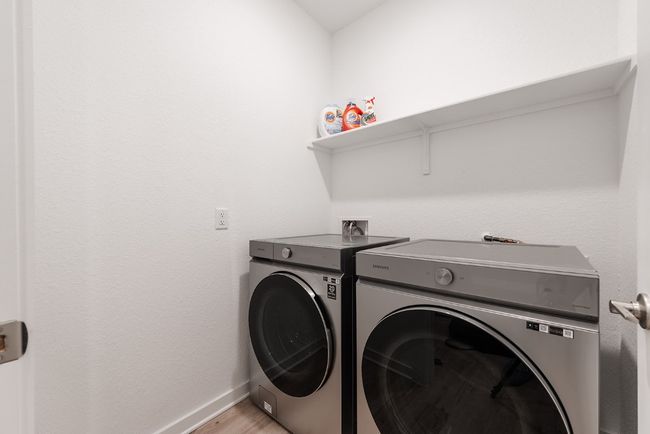 Clothes washing area featuring light wood finished floors, laundry area, washer and dryer, and baseboards | Image 28