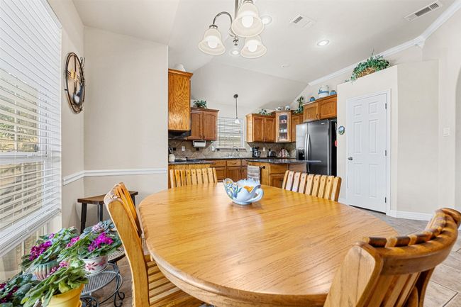 Dining room with lofted ceiling, a chandelier, ornamental molding, and baseboards | Image 12