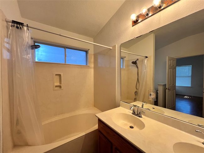 Bathroom with shower / bath combination with curtain, lofted ceiling, and double vanity | Image 8