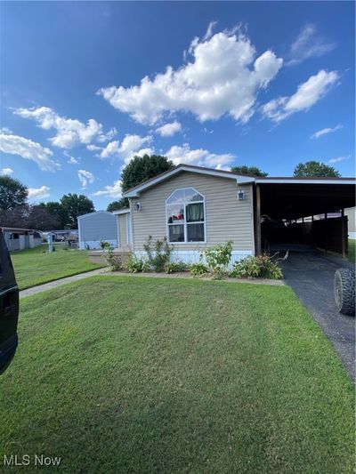 Manufactured / mobile home with a carport and a front yard | Image 1