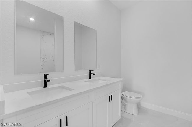 Bathroom with double vanity, tile flooring, and toilet | Image 41