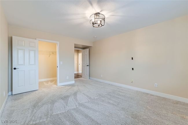 Unfurnished bedroom with light colored carpet, a walk in closet, and a closet | Image 28