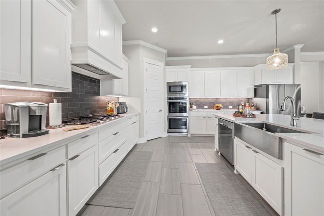 Kitchen with tasteful backsplash, Quartz Counters and pendant lighting | Image 4