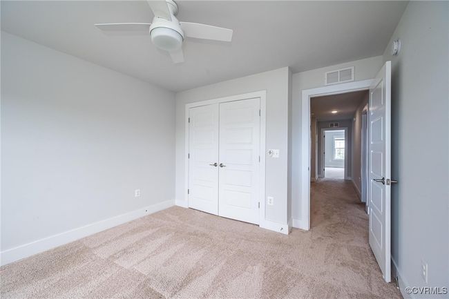 bedroom with carpet, a closet, and a ceiling fan | Image 19