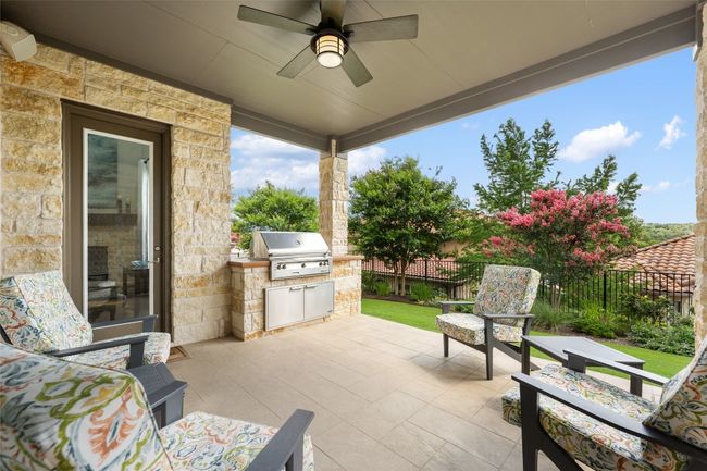Fenced backyard with an outdoor kitchen, a patio area, and ceiling fan | Image 32