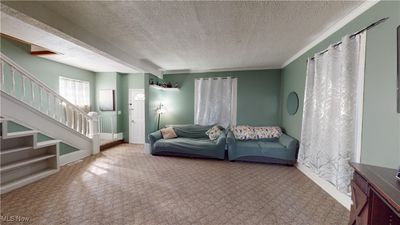 Carpeted living room featuring a textured ceiling | Image 3