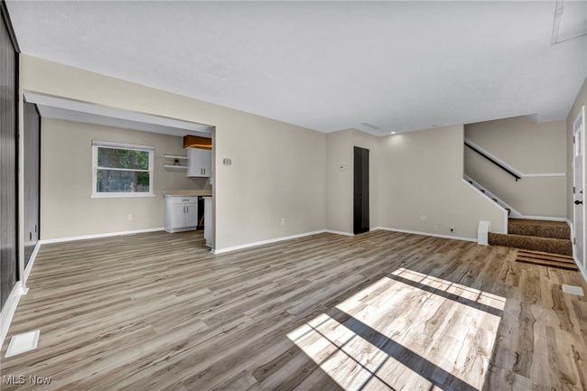 Unfurnished living room featuring light wood-style floors and stairway | Image 27